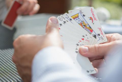 Blick über die Schulter auf die Karten eines Spielers